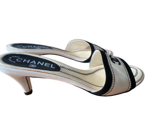 CHANEL white and black mules with signature CC.