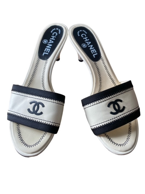 CHANEL white and black mules with signature CC.